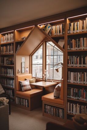 Rak buku di ruang perpustakaan dengan suasana tenang